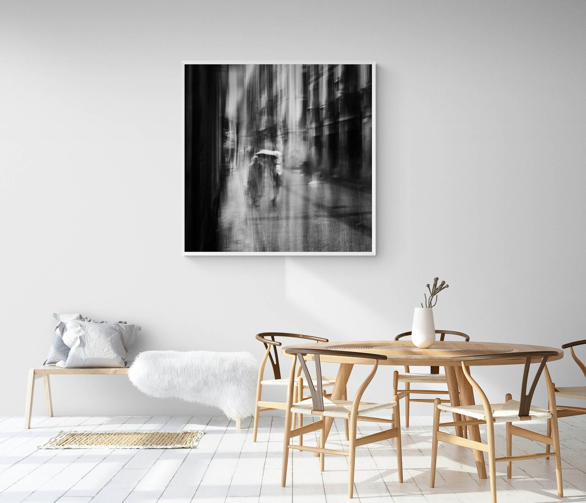 Black and white image of blurred figures under an umbrella on a rainy street in San Sebastian, Spain, creating an ethereal atmosphere.