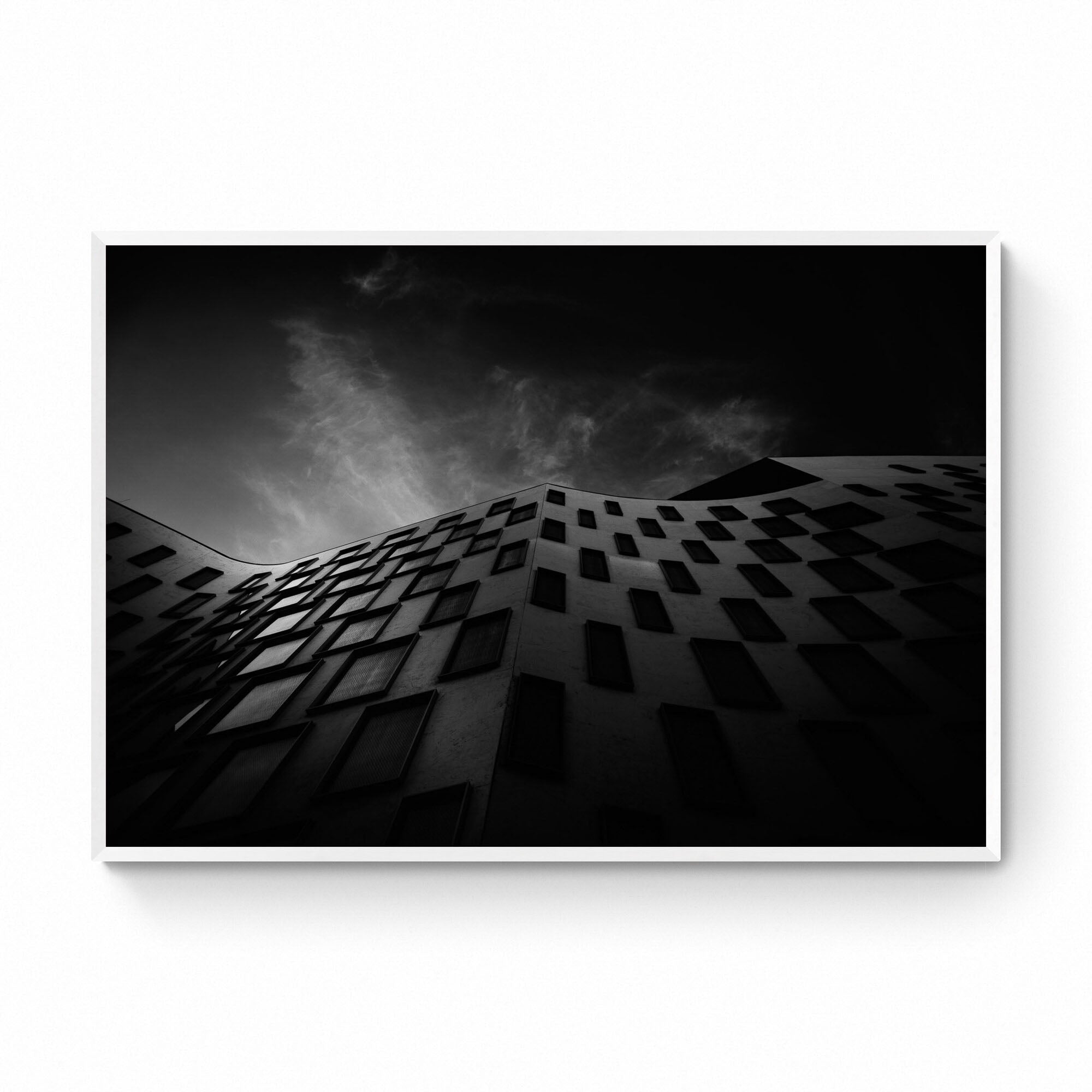 Silhouetted against the sky, the curved facade of the Vicki Sara Building at UTS, adorned with a pattern of dark windows.