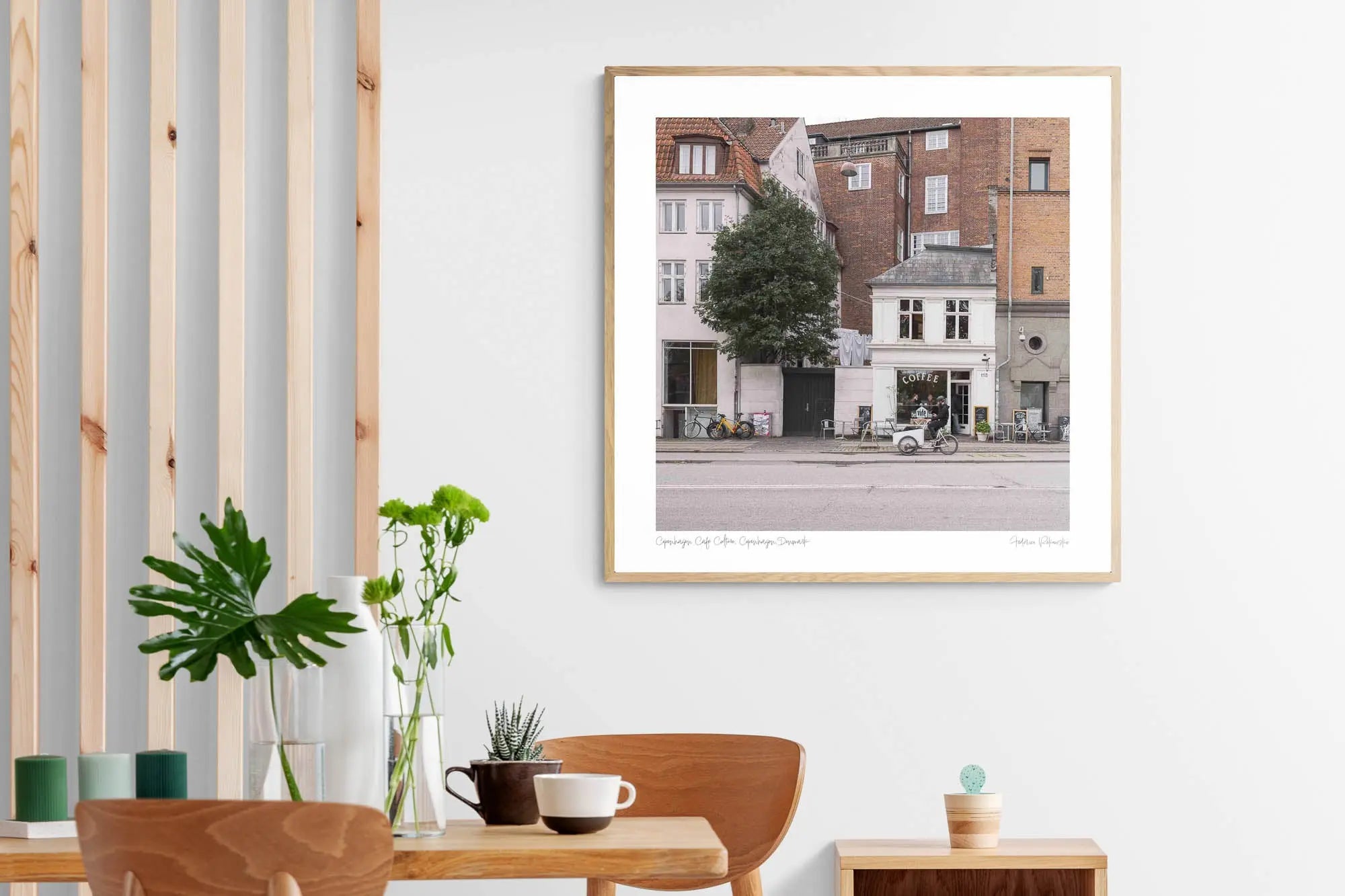 A cozy café sits nestled between classic Copenhagen buildings, with bicycles parked outside, invoking the city's relaxed urban atmosphere.