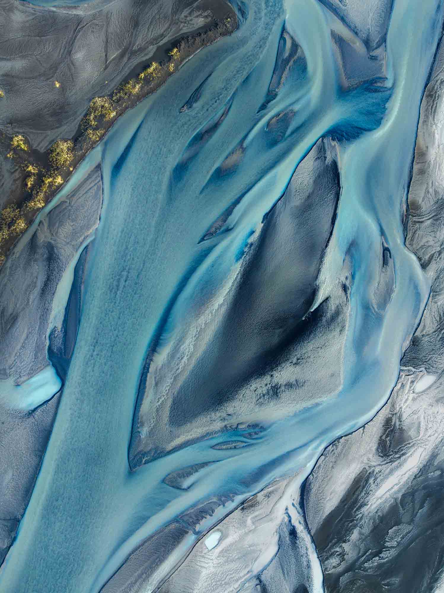 Aerial shot of Eldhraun Lava Field featuring a natural, seal-like pattern formed by glacial rivers amid the dark lava.