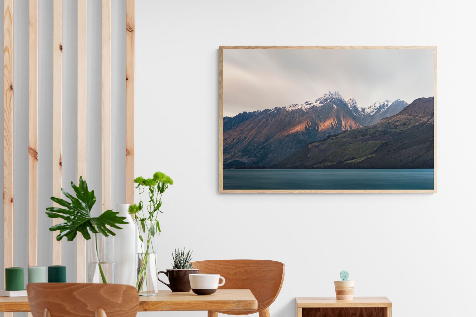 Last light of dusk casting a warm glow on the snowy peaks of mountains in Glenorchy, New Zealand, with a calm lake in the foreground.