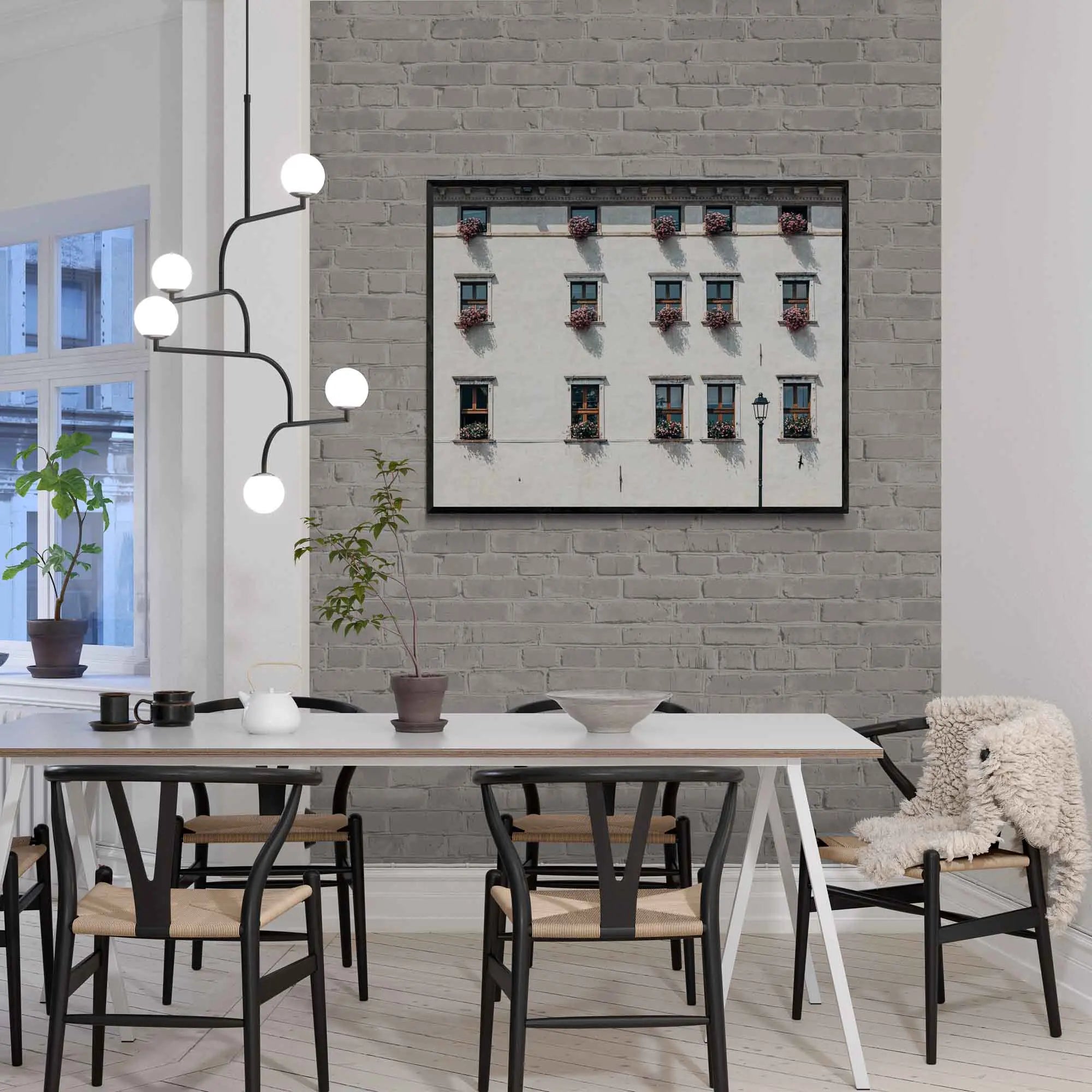 Facade of an Italian building adorned with multiple windows, each accented with vibrant pink flowers in Limone, Italy.