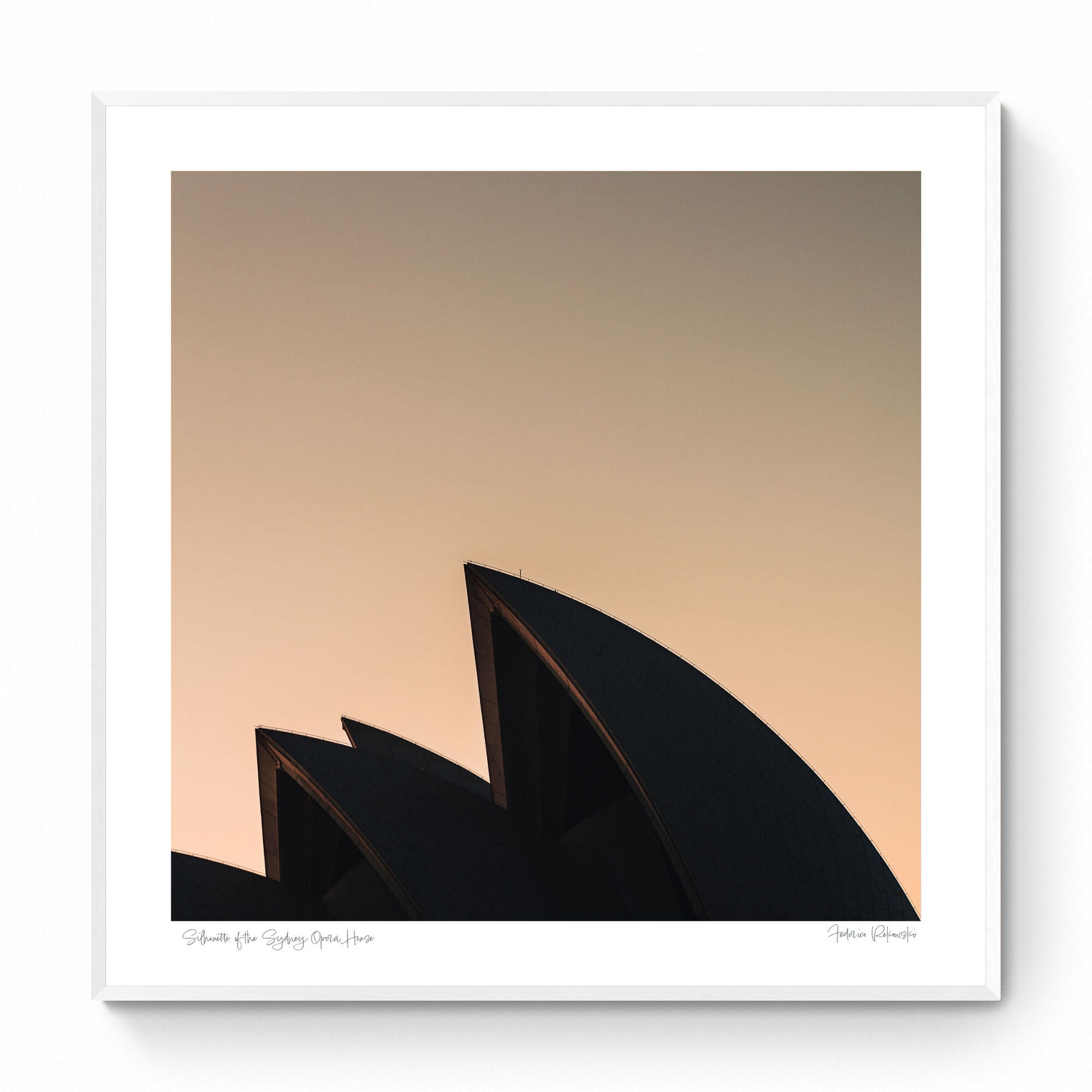 The iconic sails of the Sydney Opera House in silhouette against the warm tones of sunrise.