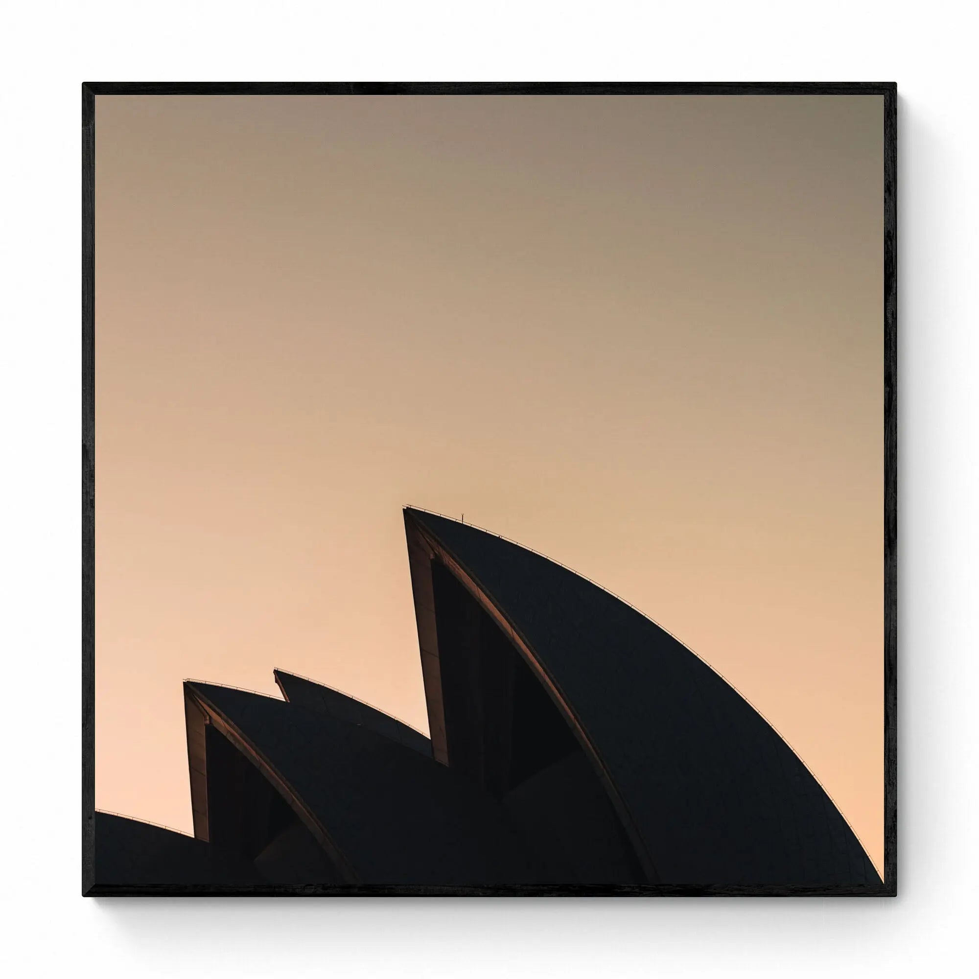The iconic sails of the Sydney Opera House in silhouette against the warm tones of sunrise.