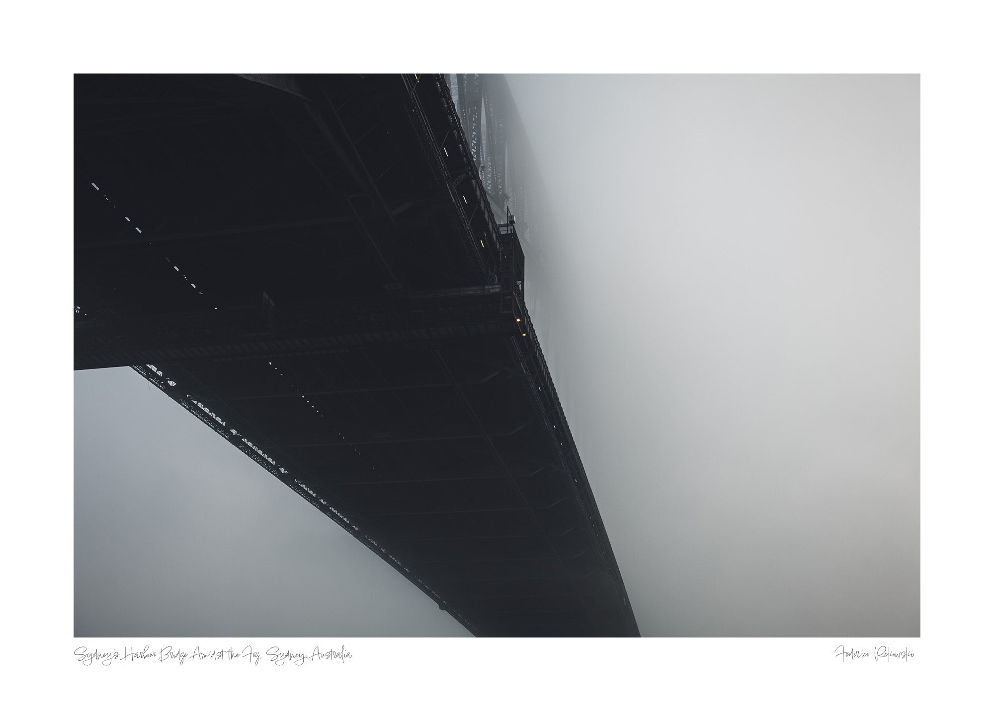 The Sydney Harbour Bridge partially obscured by fog, with its arch and lights fading into the white mist.