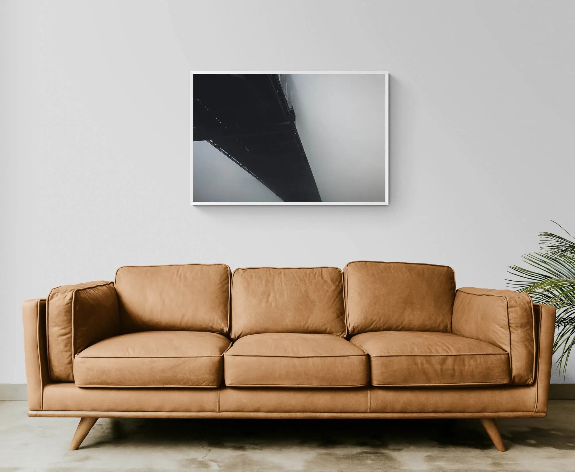 The Sydney Harbour Bridge partially obscured by fog, with its arch and lights fading into the white mist.