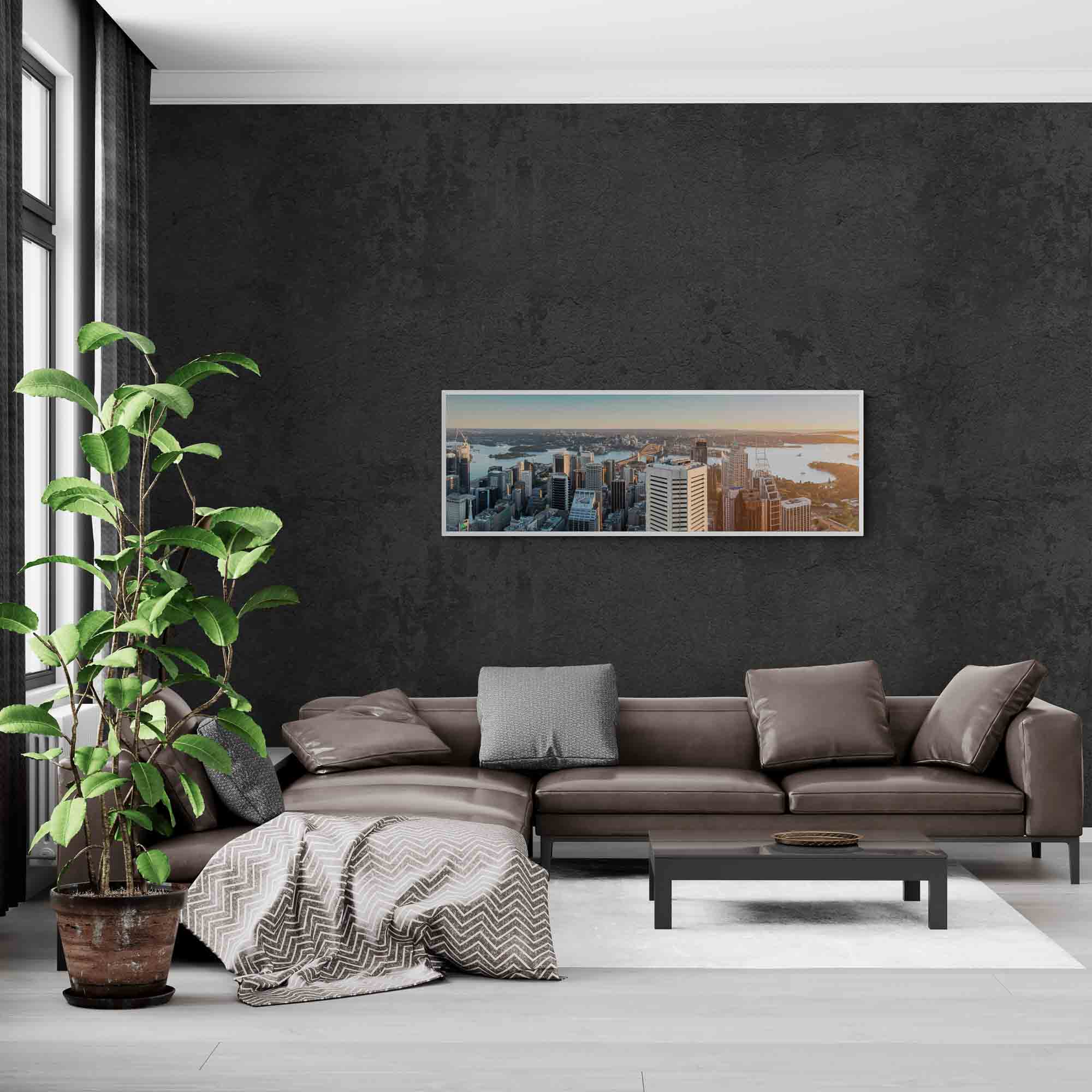 Panoramic view of Sydney Harbour at sunrise, with sunlight bathing the cityscape and water in golden hues.