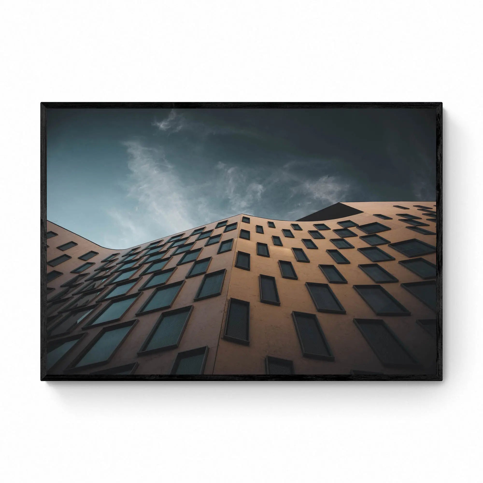 The distinctive exterior of the Vicki Sara Building at UTS, featuring a unique pattern of windows, set against the backdrop of a clear sky.