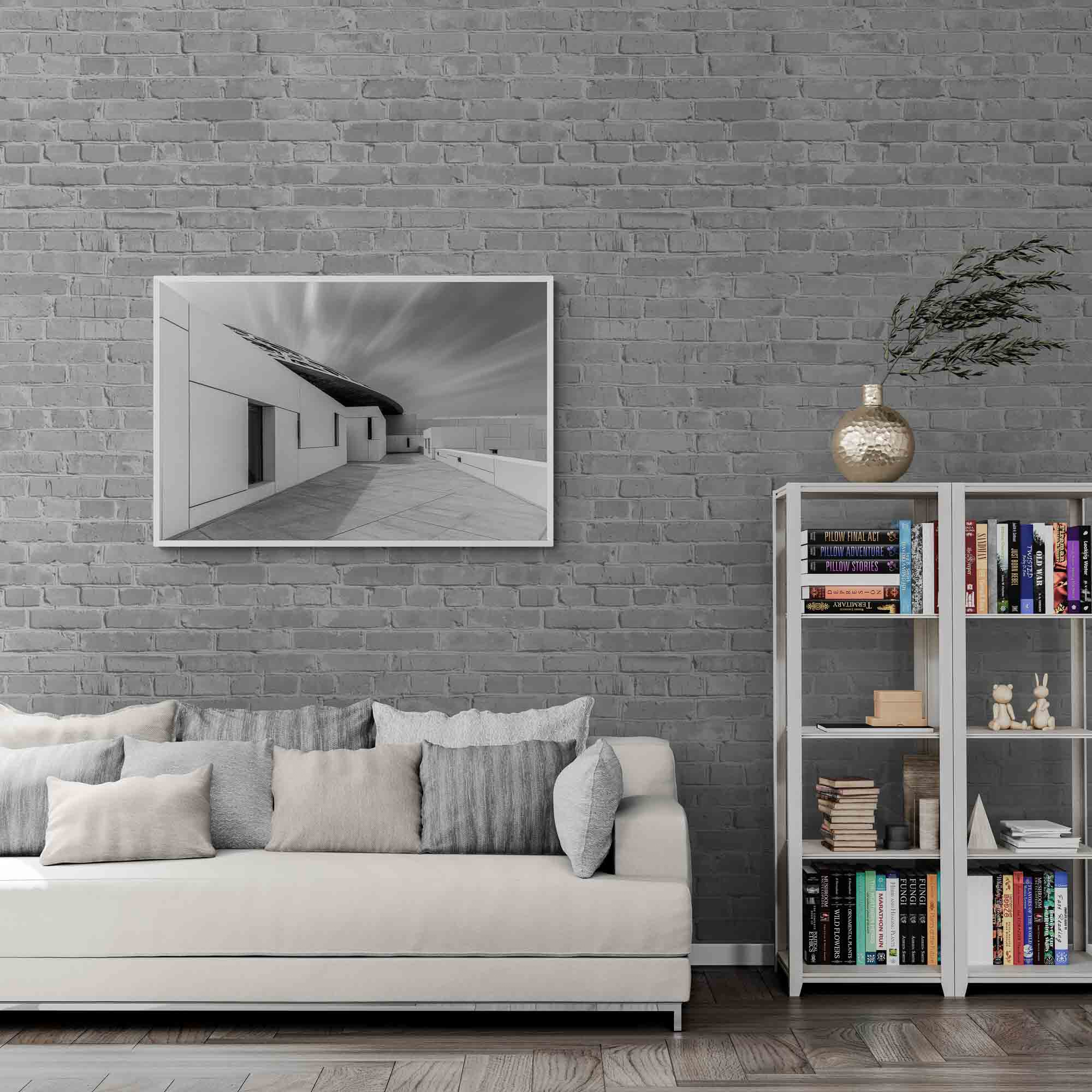 A long exposure black and white image of the Louvre Abu Dhabi showing the sharp angles of the museum's architecture against the smooth streaks of clouds in the sky.
