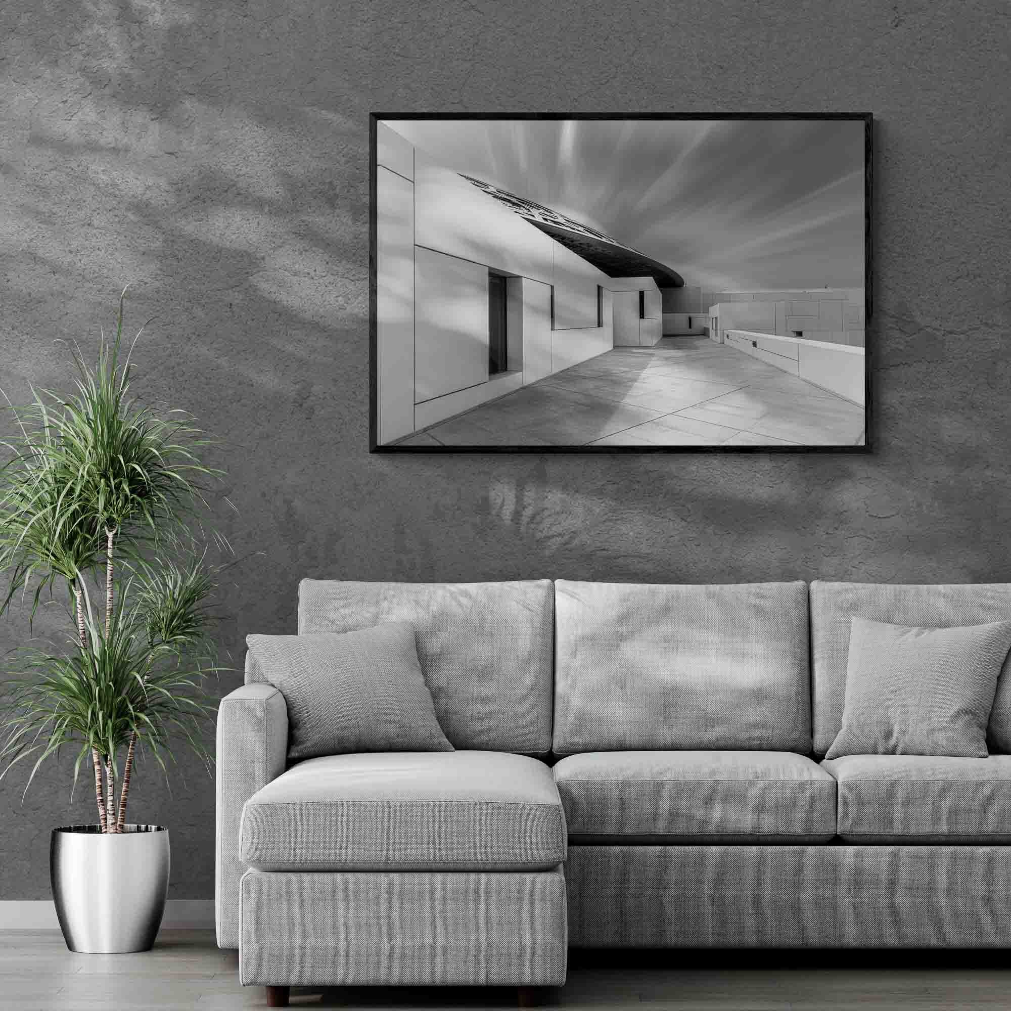 A long exposure black and white image of the Louvre Abu Dhabi showing the sharp angles of the museum's architecture against the smooth streaks of clouds in the sky.