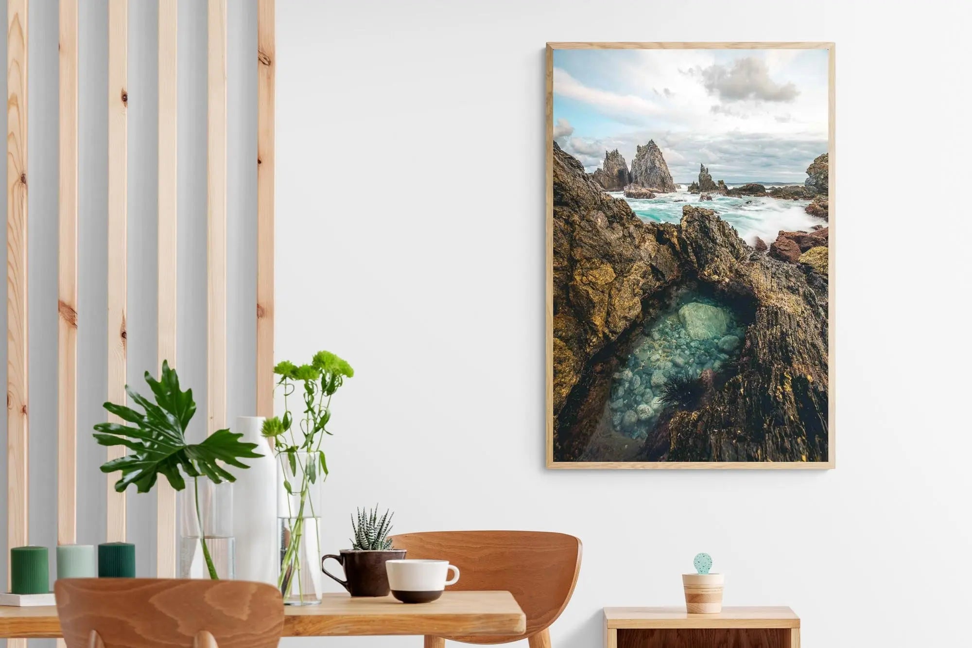 Rugged rock formations of Camel Rock in Bermagui with a natural tide pool in the foreground and turbulent sea in the background under a cloudy sky.
