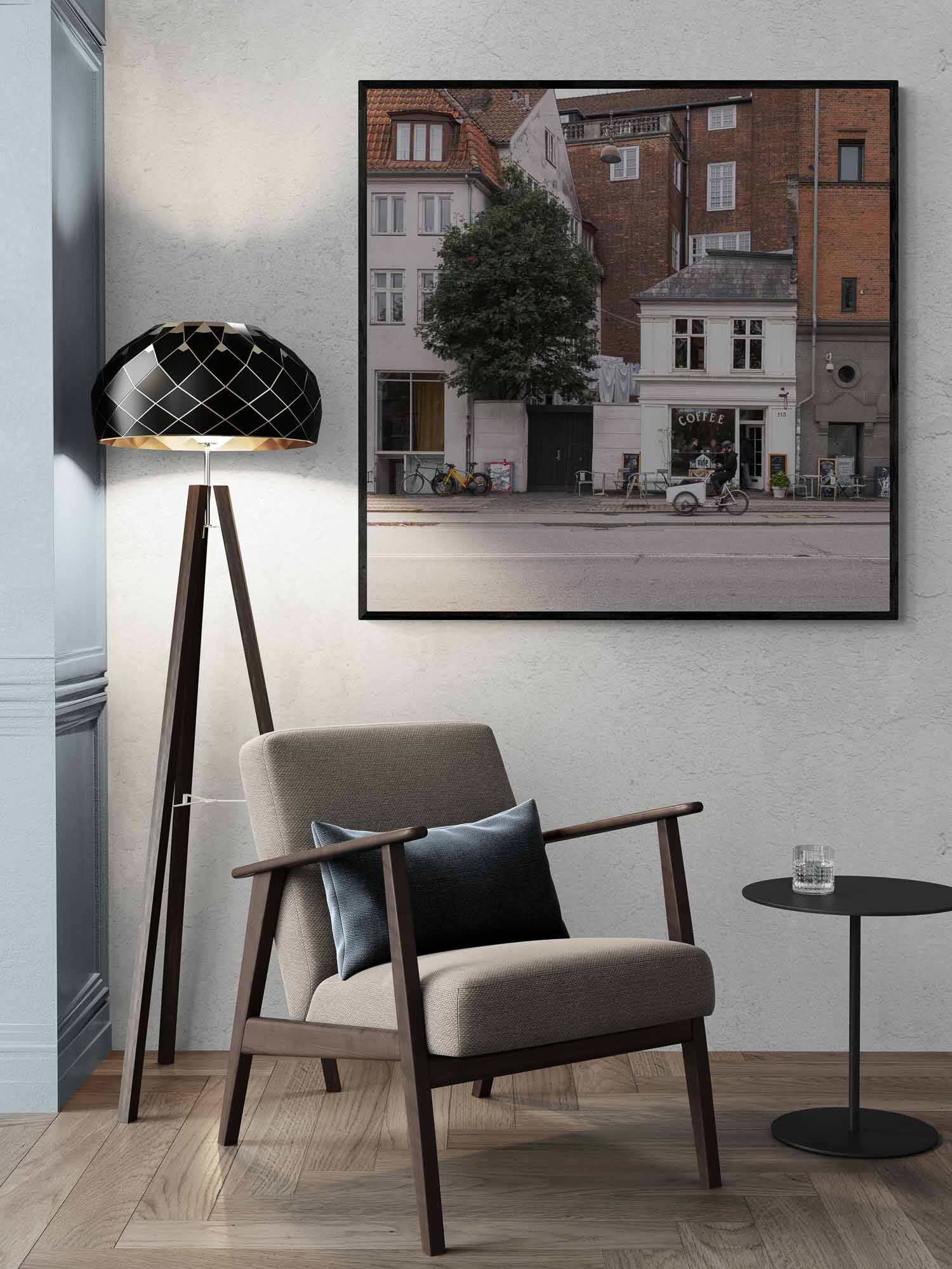 A cozy café sits nestled between classic Copenhagen buildings, with bicycles parked outside, invoking the city's relaxed urban atmosphere.