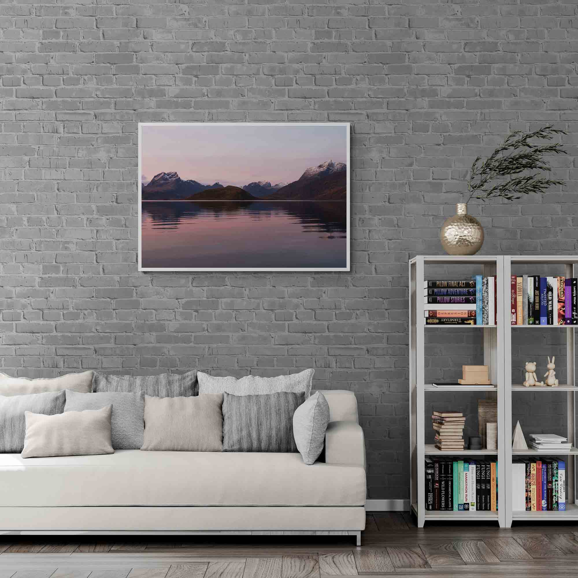 Sunrise at Fredvang in Lofoten, with snow-capped mountains reflecting in calm waters under a pastel-hued sky.