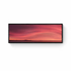 Sunrise over Moeraki Beach depicted in a photograph, showcasing vibrant red and pink clouds stretched across the sky.