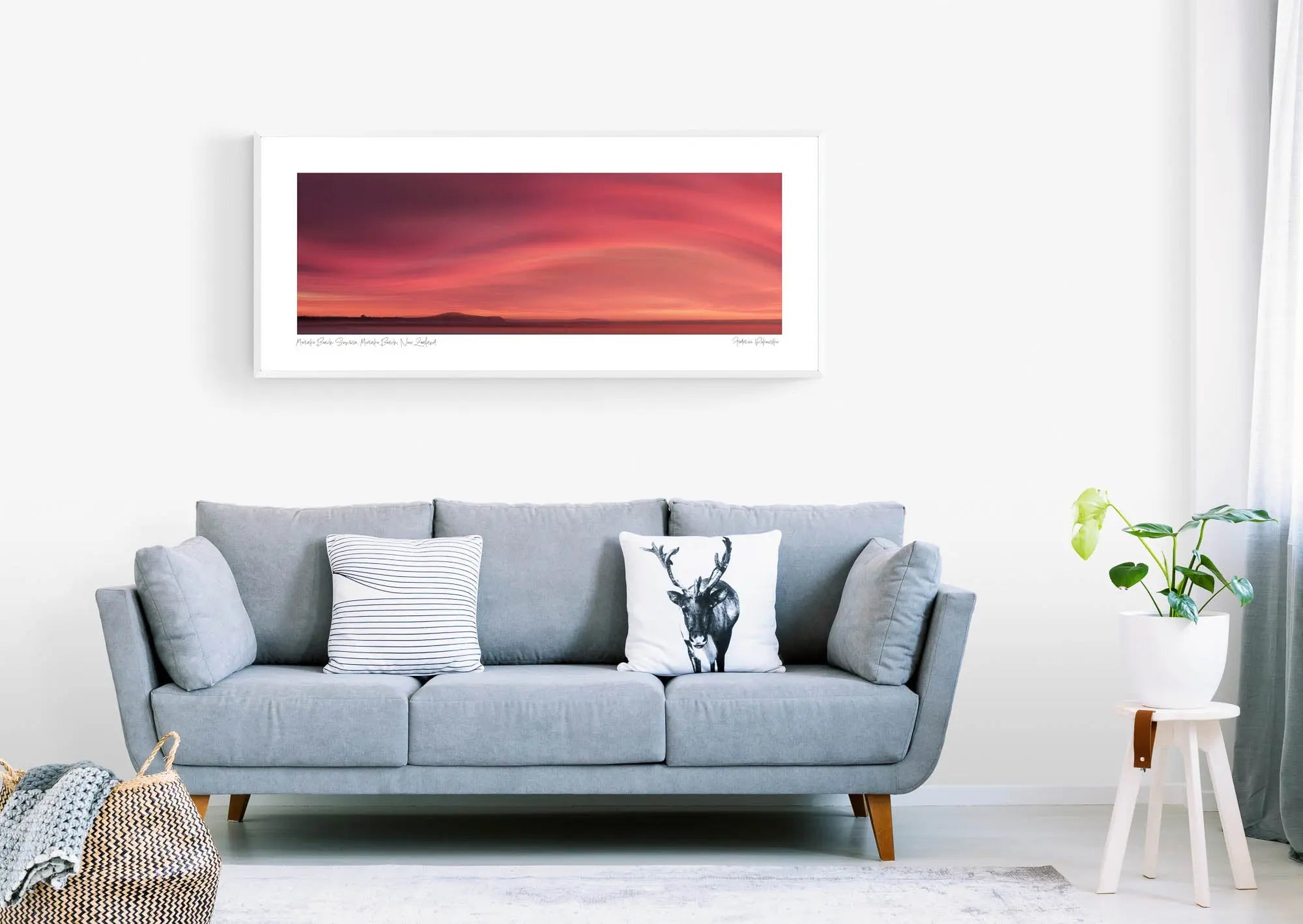 Sunrise over Moeraki Beach depicted in a photograph, showcasing vibrant red and pink clouds stretched across the sky.