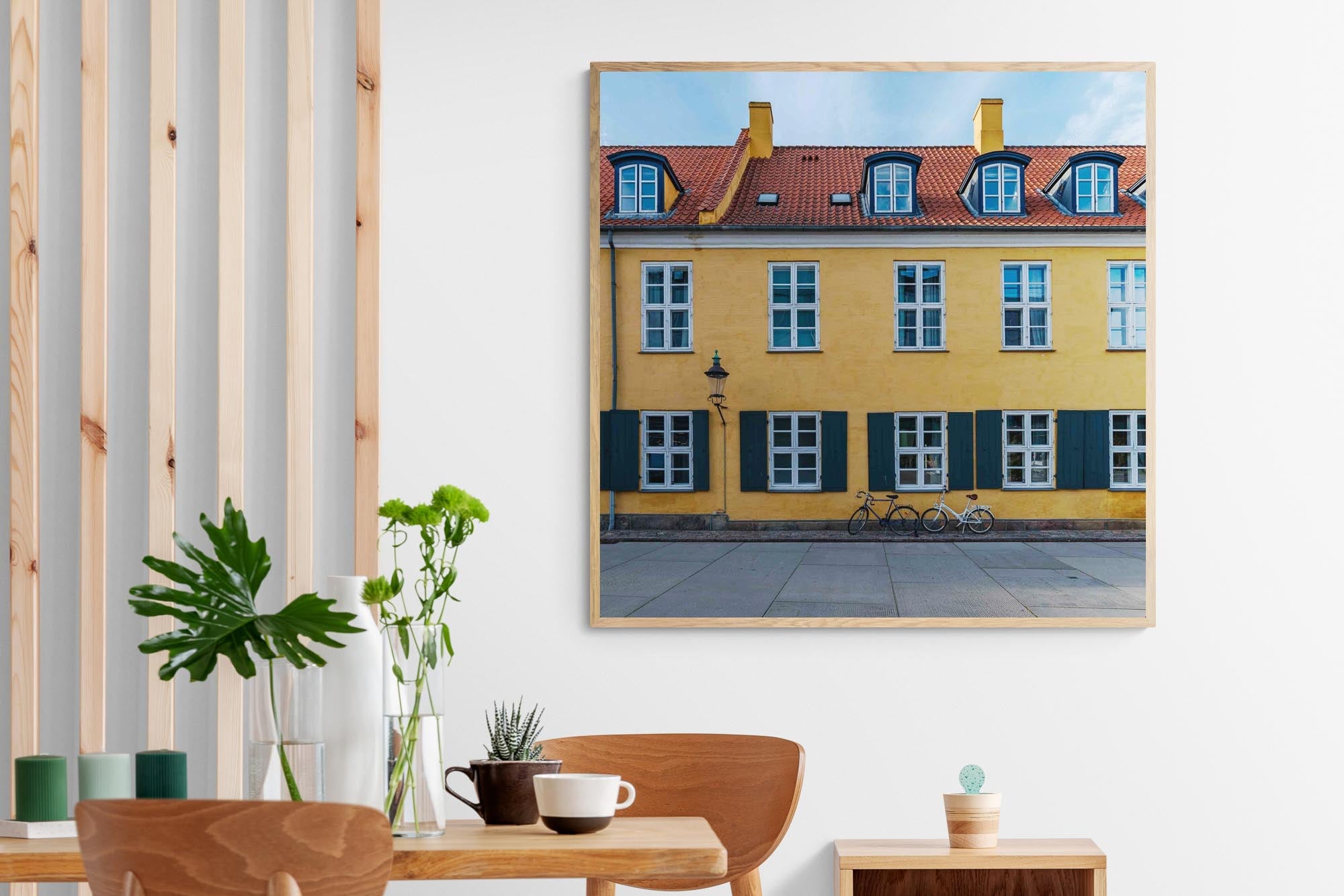 "Colorful image of a yellow building with green shutters and a bicycle in front on a street in Copenhagen, Denmark."