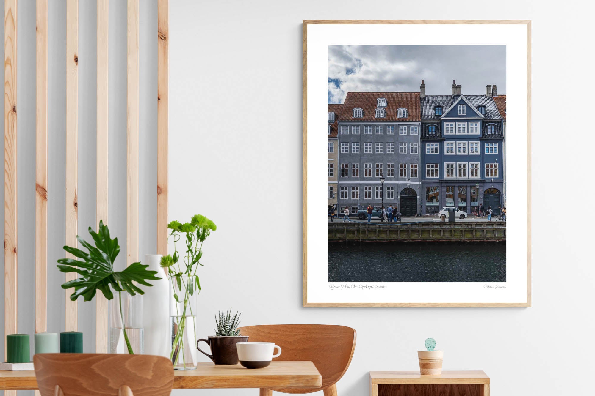 Colorful buildings along the Nyhavn canal in Copenhagen, with people walking and bikes lining the harborside.