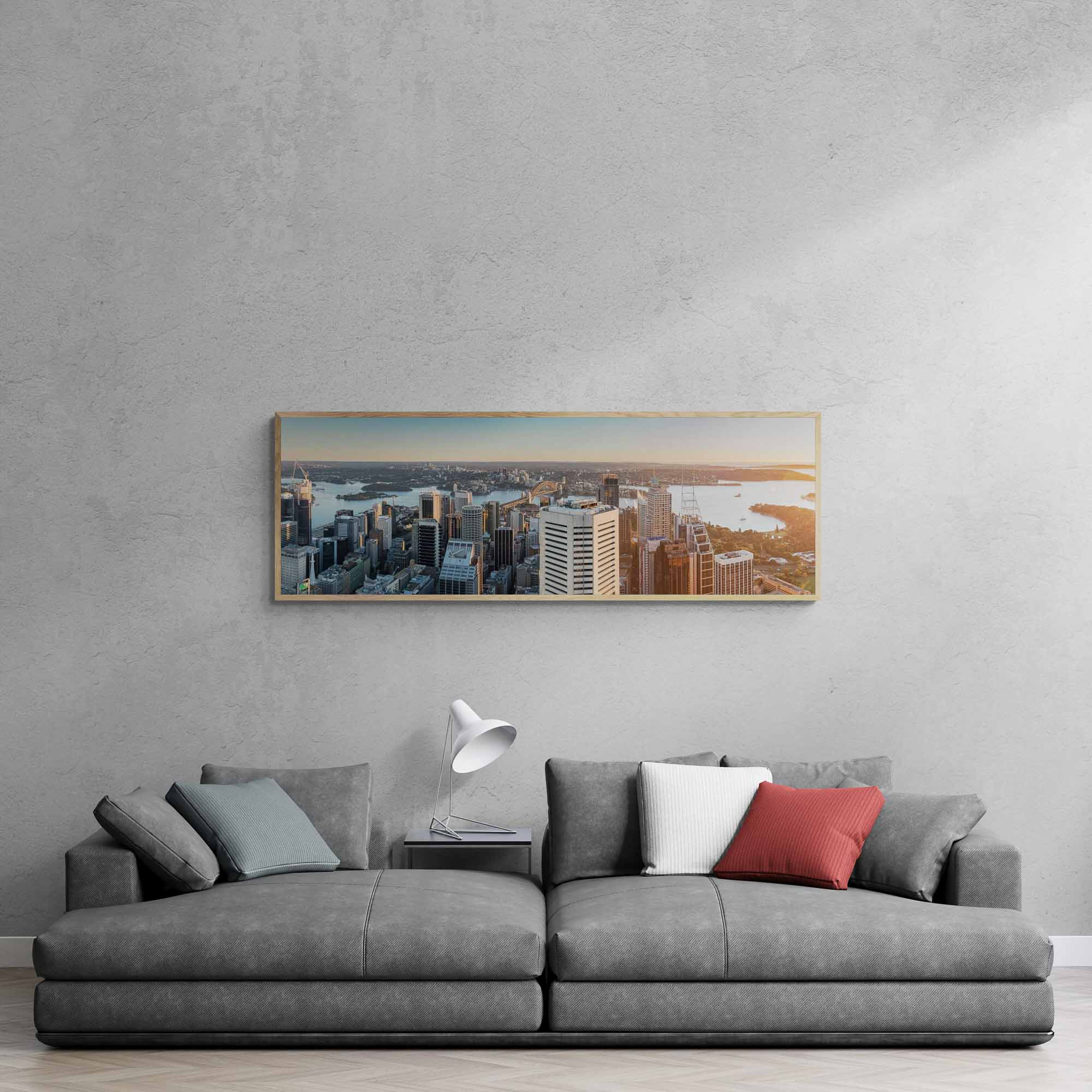 Panoramic view of Sydney Harbour at sunrise, with sunlight bathing the cityscape and water in golden hues.
