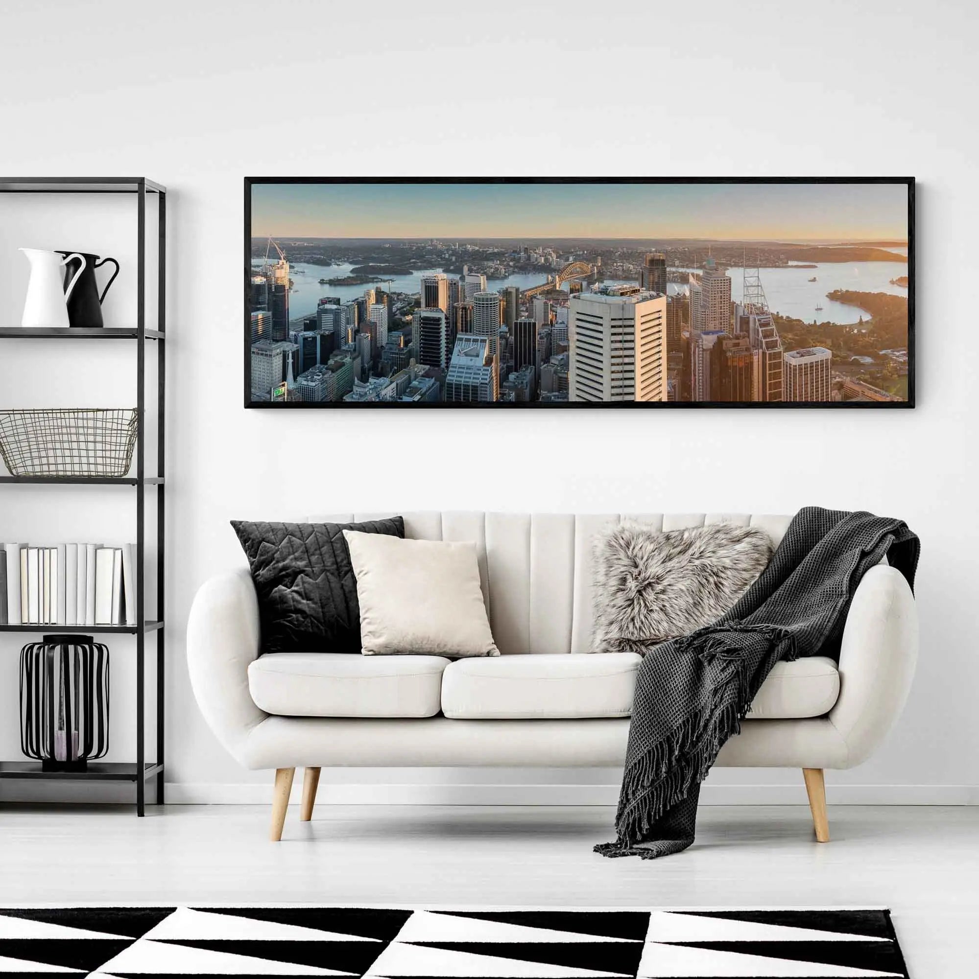 Panoramic view of Sydney Harbour at sunrise, with sunlight bathing the cityscape and water in golden hues.