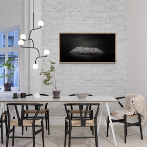 "Black and white image of an isolated island in San Sebastian, Spain, with radiant white foliage under a dark sky."