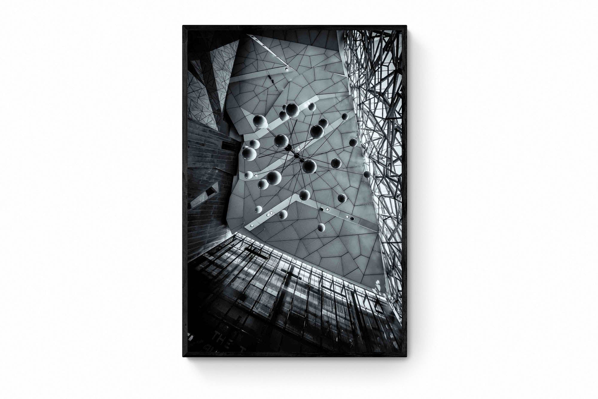 Black and white photo of the abstract geometric ceiling at Federation Square in Melbourne, with spherical elements hanging against the angular design.