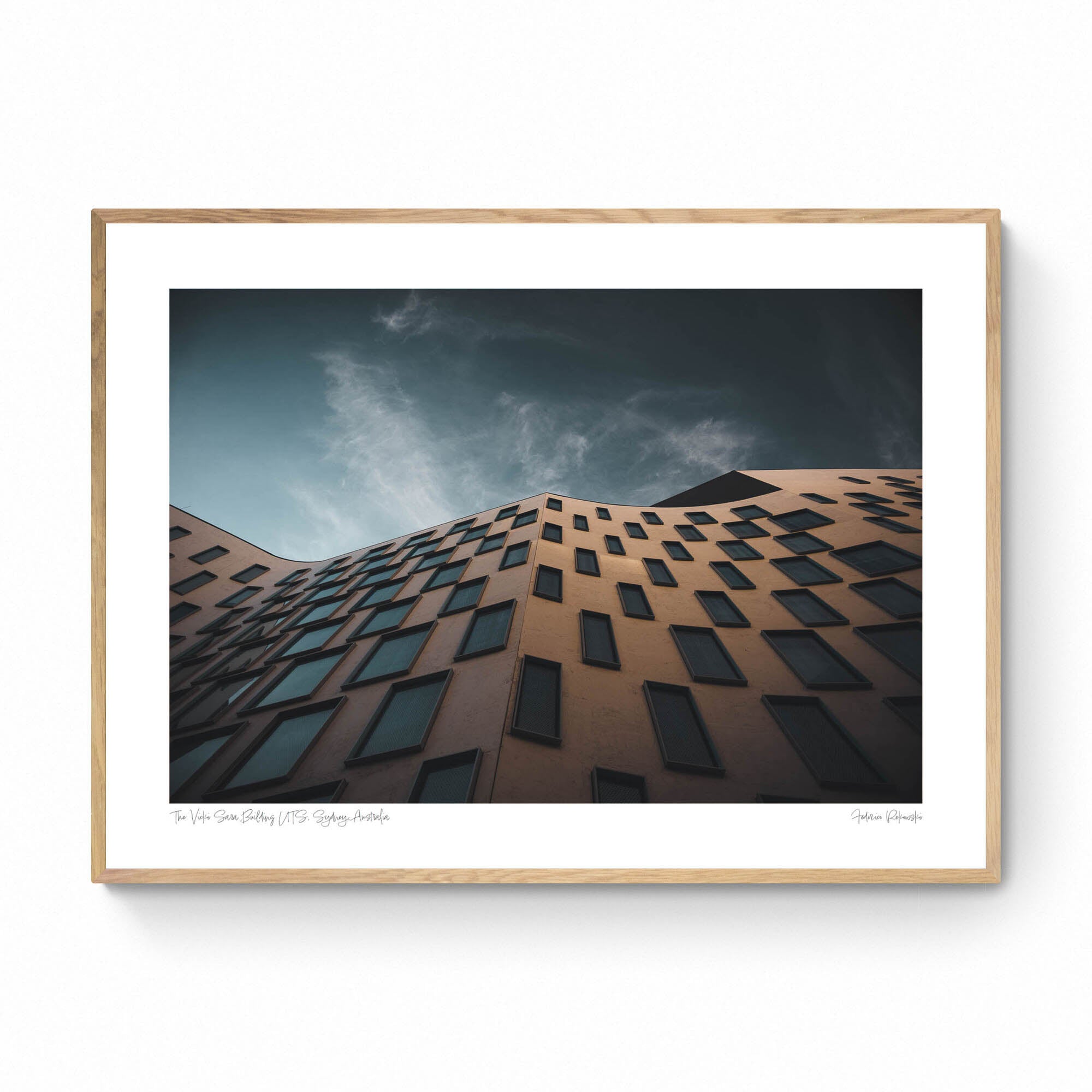 The distinctive exterior of the Vicki Sara Building at UTS, featuring a unique pattern of windows, set against the backdrop of a clear sky.