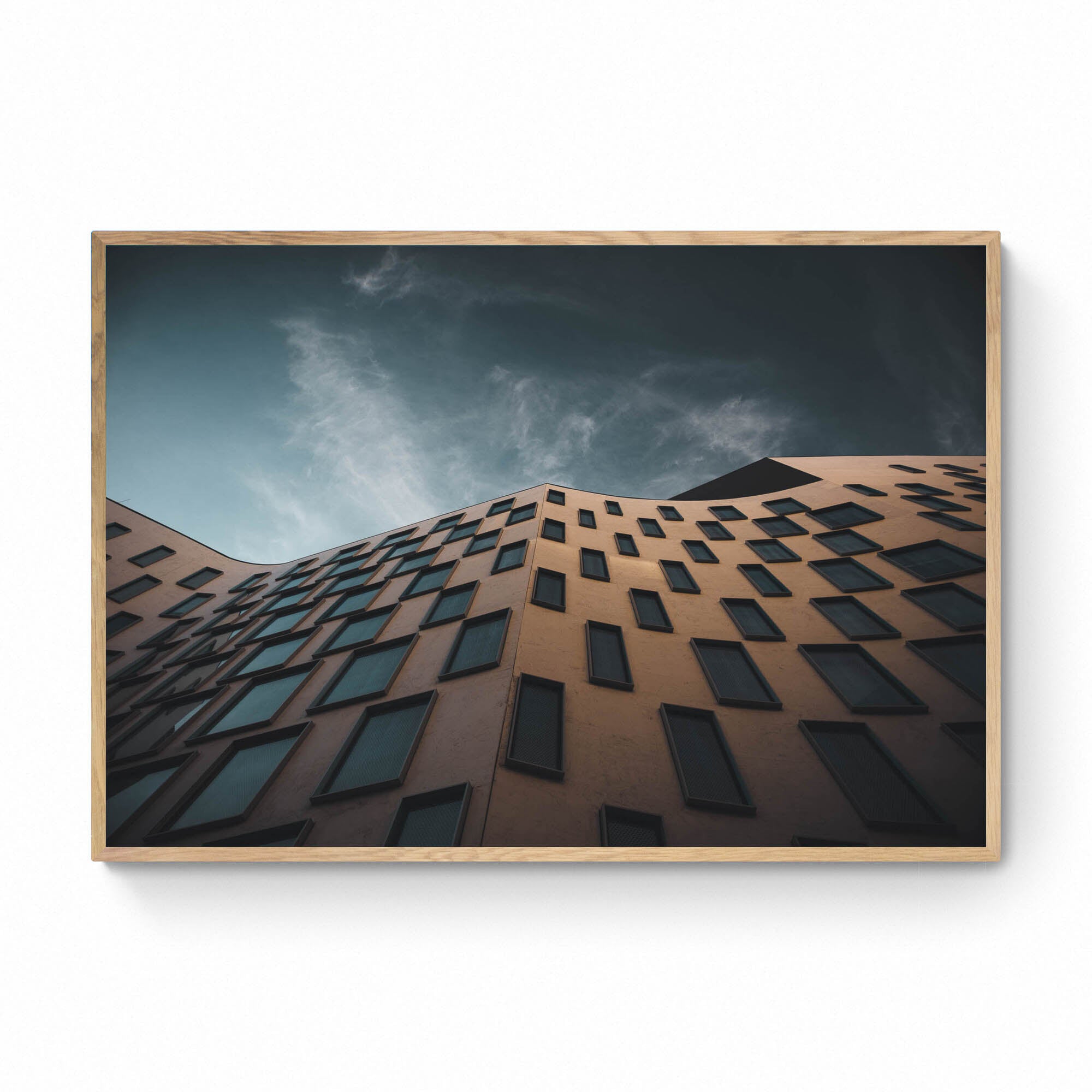 The distinctive exterior of the Vicki Sara Building at UTS, featuring a unique pattern of windows, set against the backdrop of a clear sky.