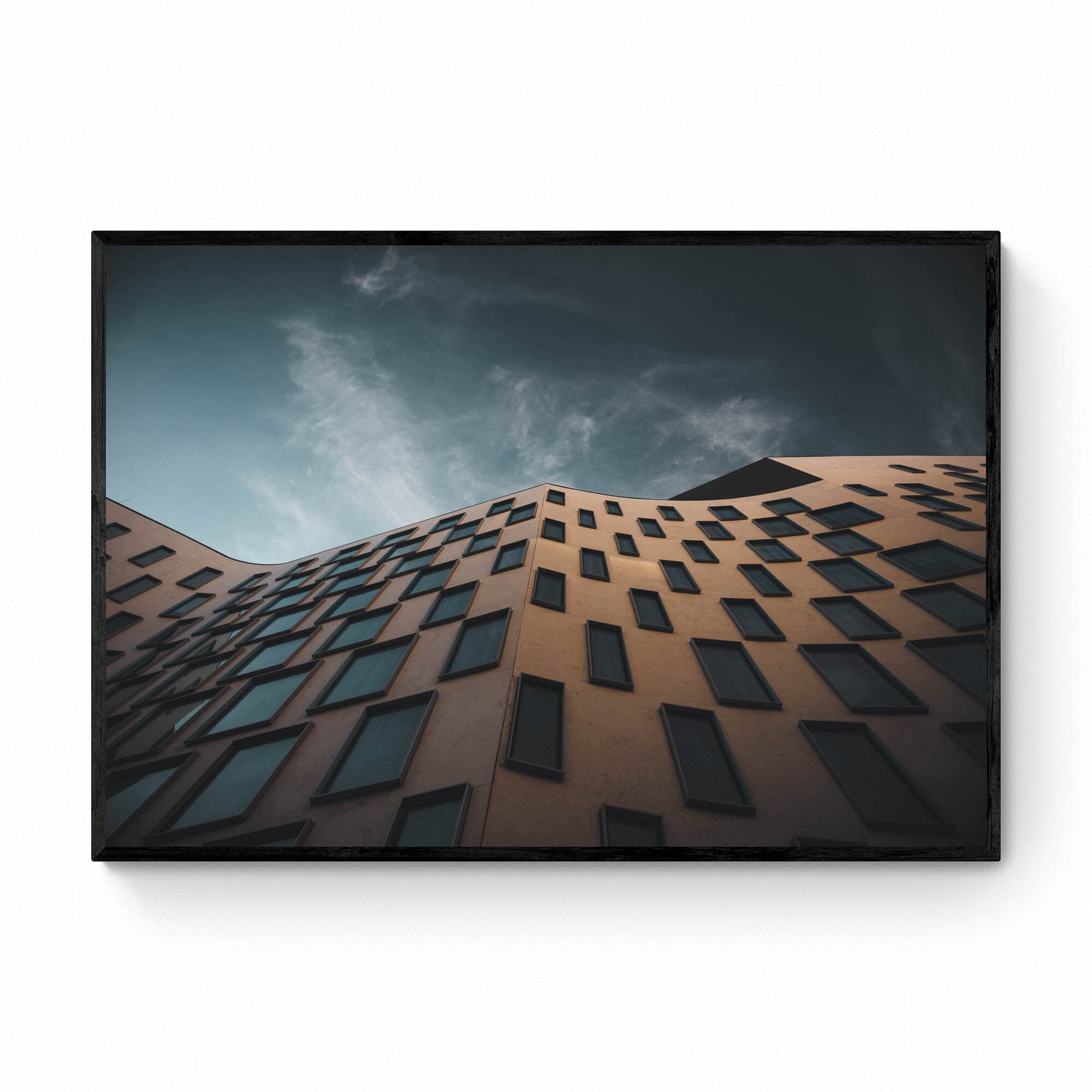 The distinctive exterior of the Vicki Sara Building at UTS, featuring a unique pattern of windows, set against the backdrop of a clear sky.