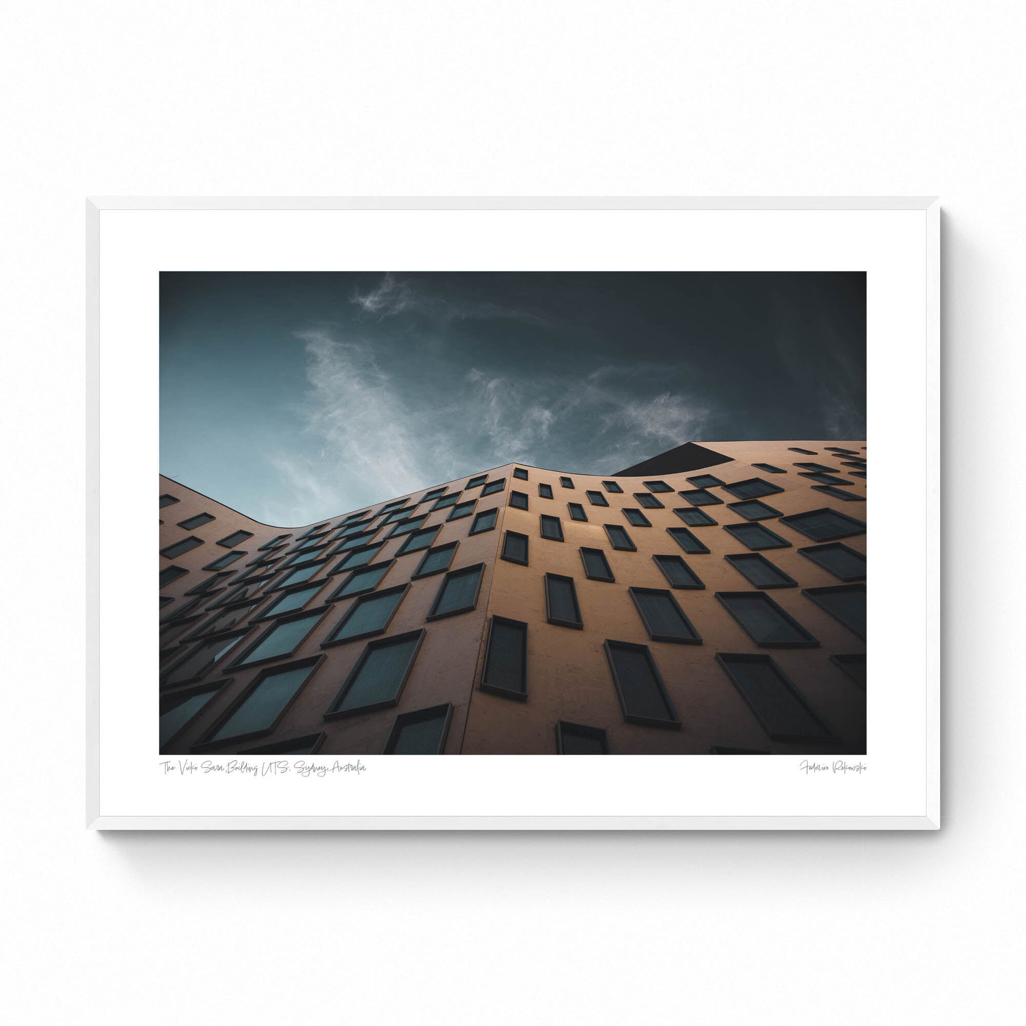 The distinctive exterior of the Vicki Sara Building at UTS, featuring a unique pattern of windows, set against the backdrop of a clear sky.