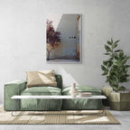 A single tree with autumn-colored leaves beside a large, plain wall with small openings, in Zaragoza, Spain.