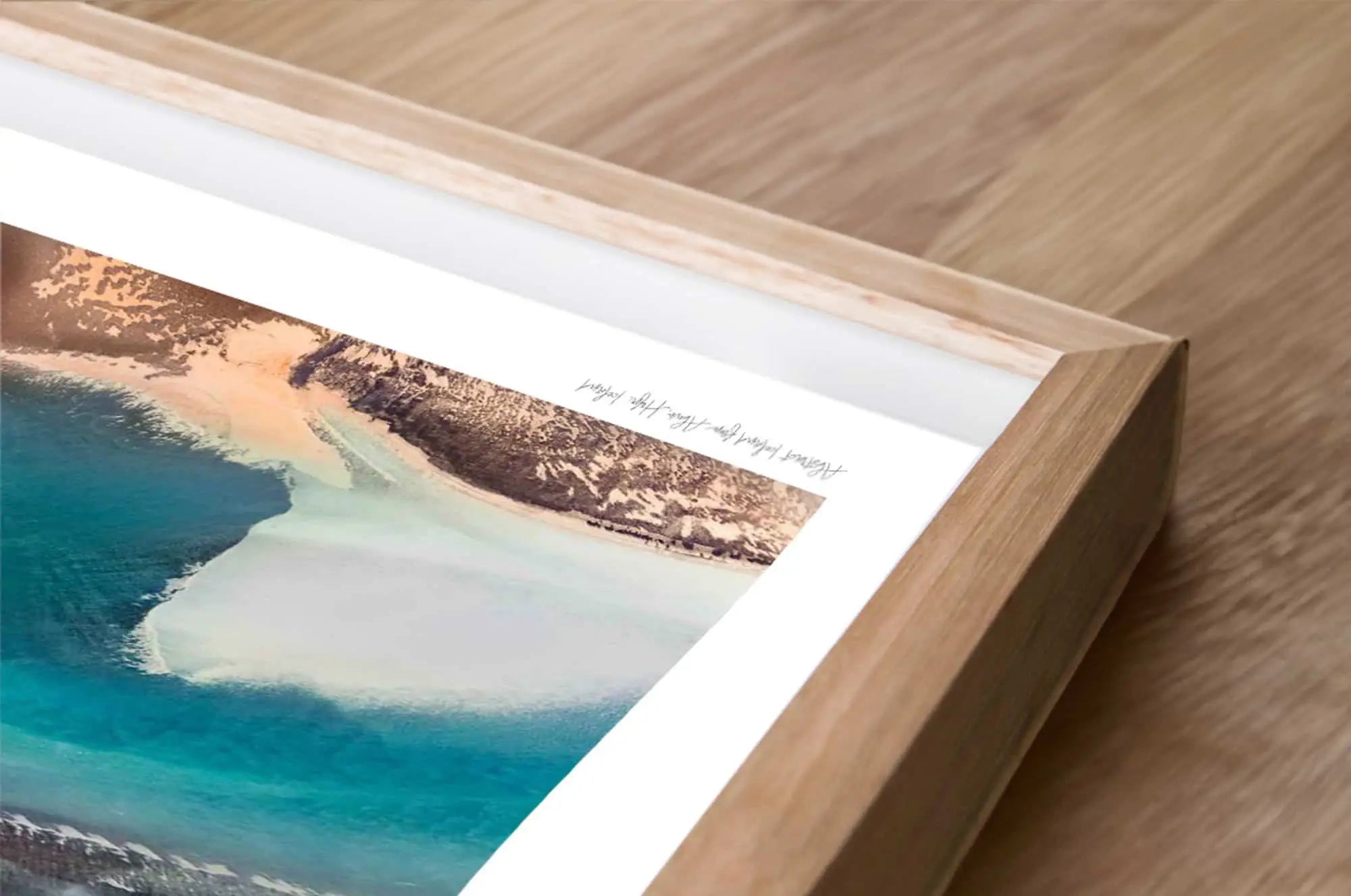 Framed photograph of a beach scene on a wooden surface